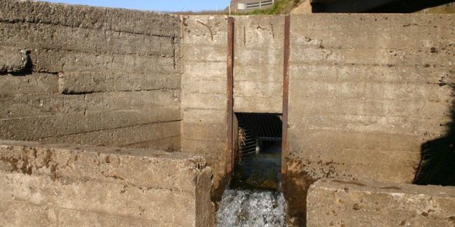 a concrete wall with a drainage channel